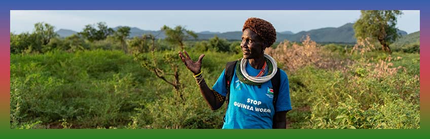 A woman wearing a blue tshirt that reads Stop Guinea Worm.