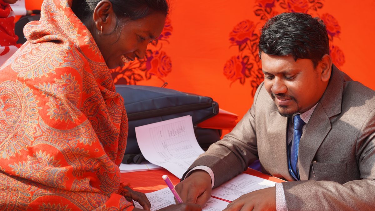A women's group participant registers for a Booth Camp in Paba, Rajshahi with Paba Upazila (sub-district) Facilitator, January 18 2026.