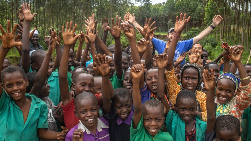 Ugandan school children pose with Carter Center team member.