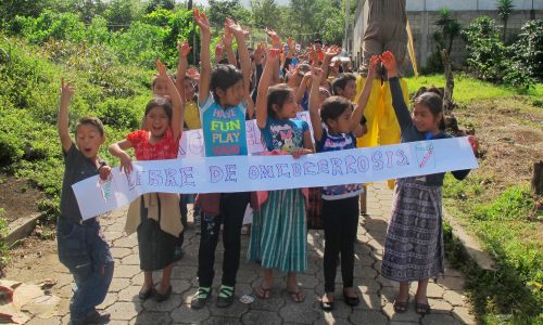 Guatemalan children hold a sign
