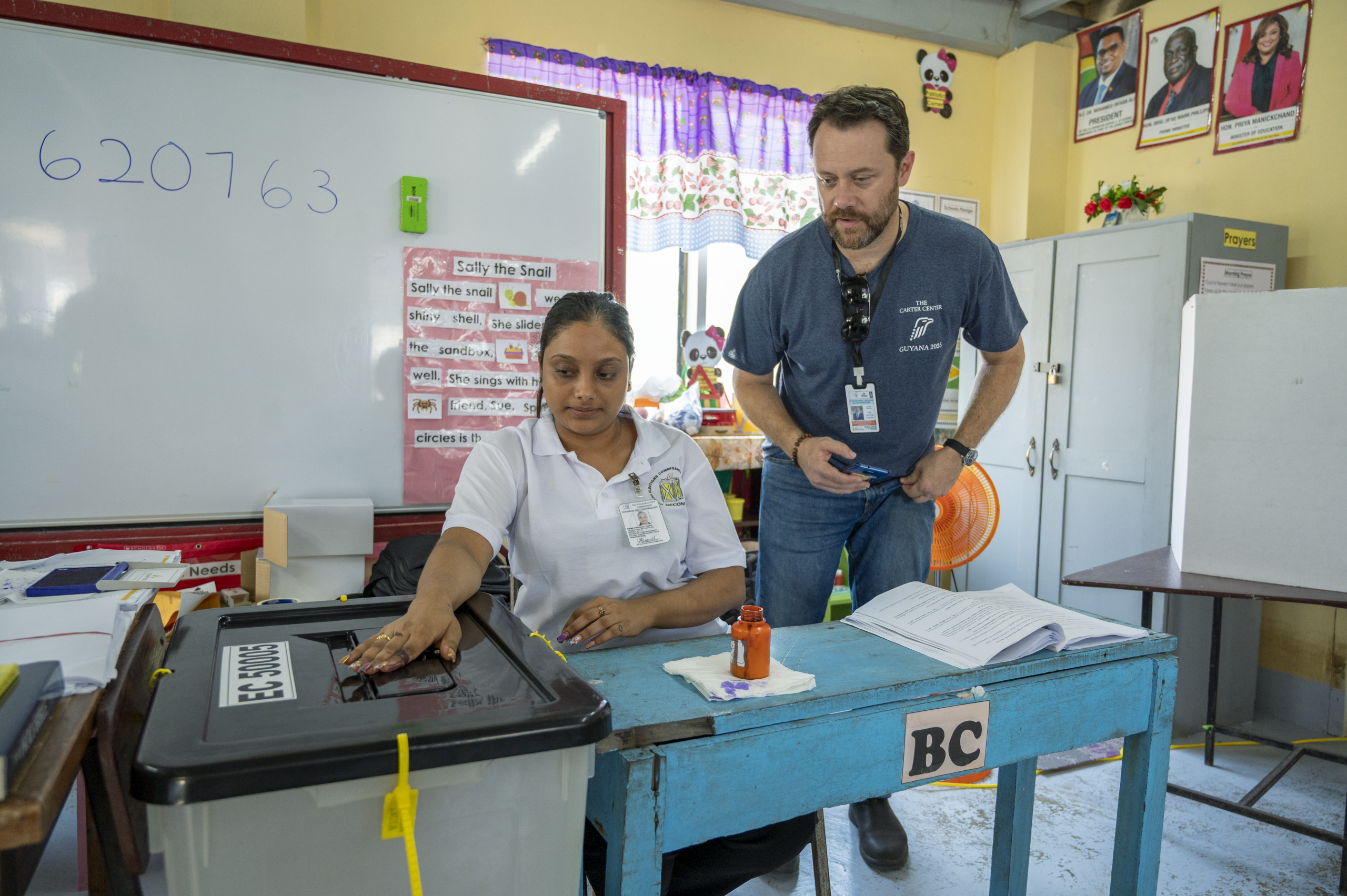 Jason stands next to worker.