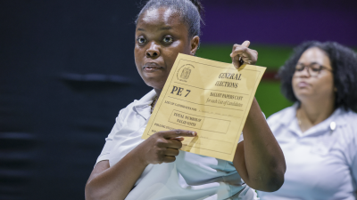Poll worker points to document.