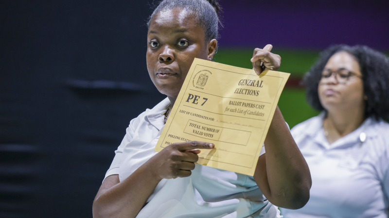 Poll worker points to document.