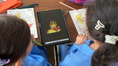 two kids look at materials on a table