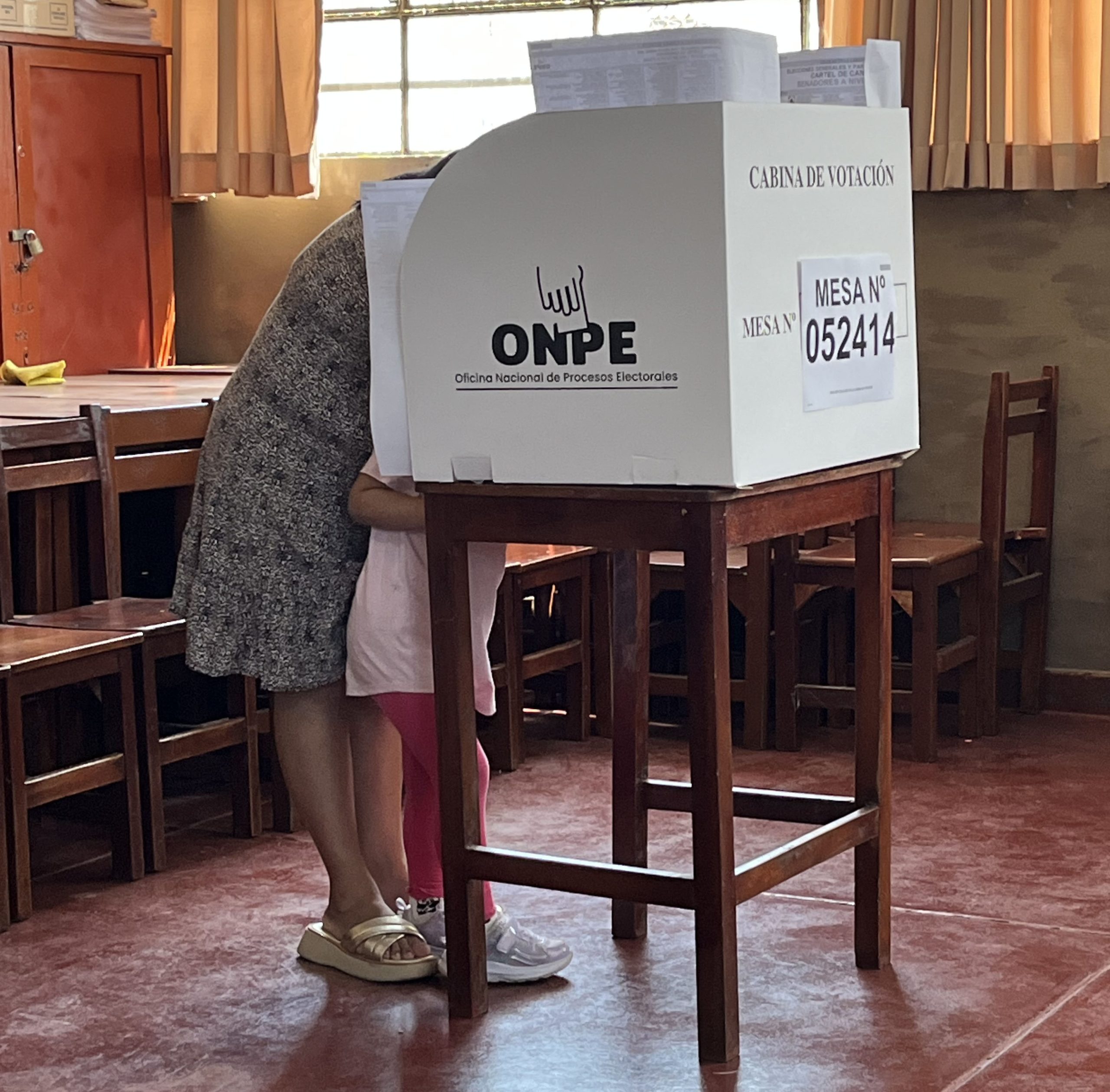 A mother casts a vote during Peru’s April 12 election, accompanied by her child. 
