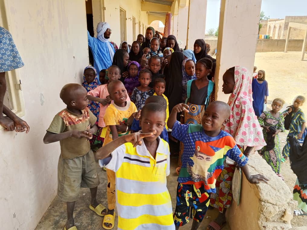 Many students in colorful shirts gather for a group photo.