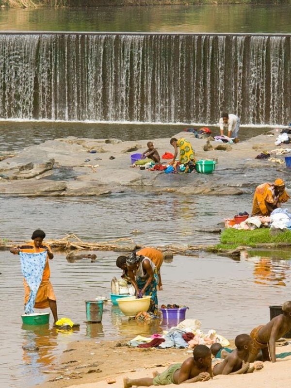 women wash laundry in a river