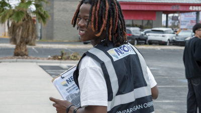 A young man looks back at the camera and smiles.